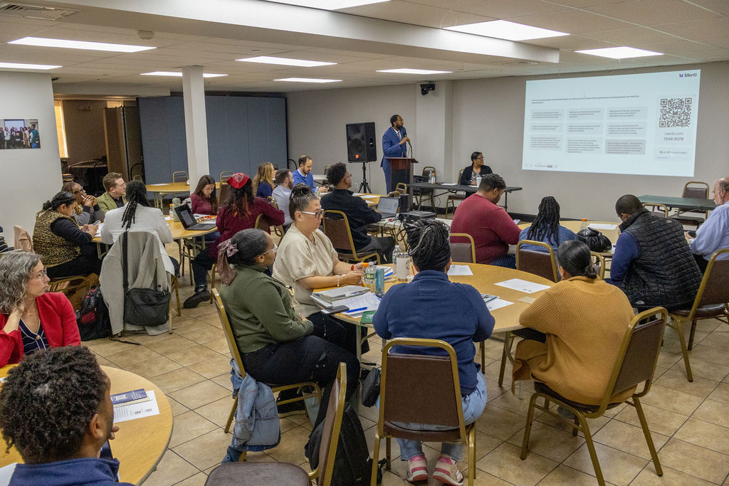 group of collaborative members meeting in a room with tables and chairs