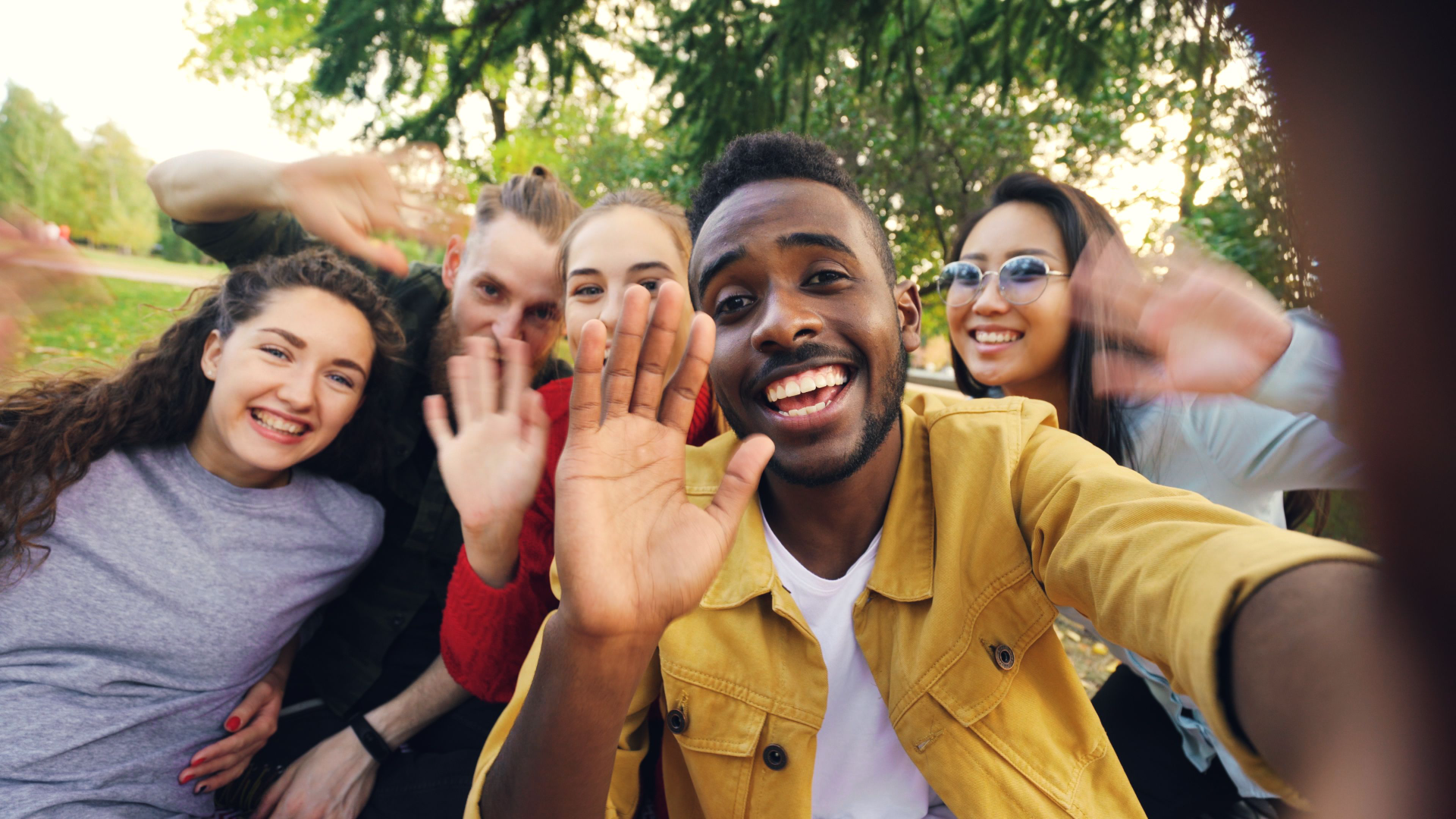Group of young adults smiling and taking a selfie